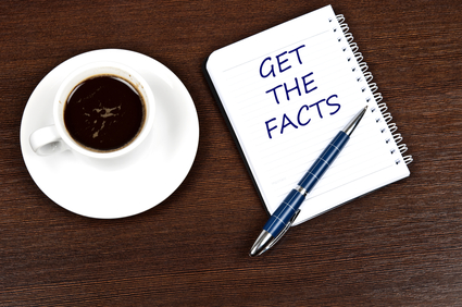 desktop with coffee and pen and an open notebook that reads "Get The Facts"