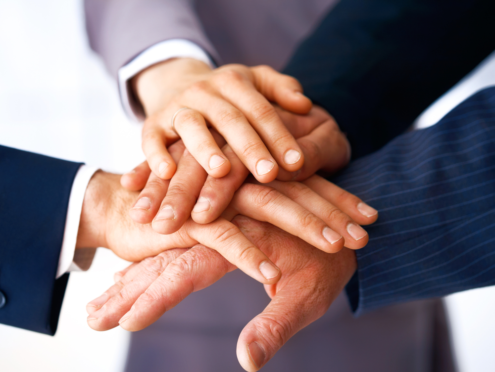 Close-up of business people's hands stacked on top of one another - teamwork concept